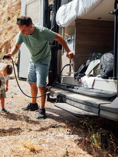father-and-children-cooling-down-by-camper-van and rv plumbing